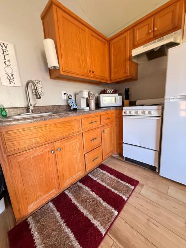 a kitchen with wooden cabinets and a white refrigerator at Qualla Cabins and Motel Cherokee near Casino in Whittier