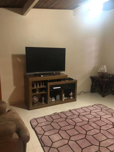 salon z telewizorem z płaskim ekranem w centrum rozrywki w obiekcie Casa de hospedes w mieście São Lourenço