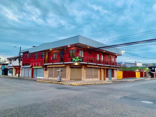 a red building on the side of a street at Hotel Costa del Sol in Puerto Limón