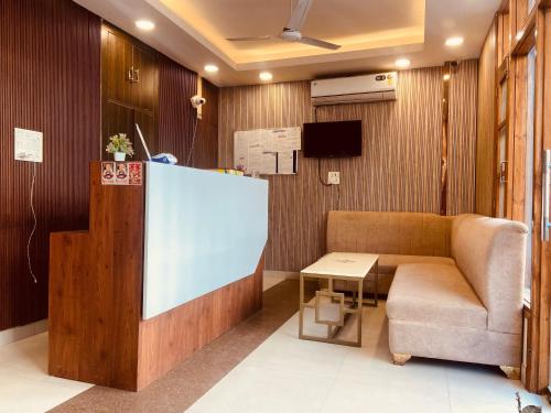 a waiting room with a couch and a table at HOTEL O THE VIRAAT in Noida