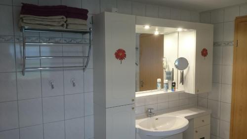 a white bathroom with a sink and a mirror at Crosta Brava in Großdubrau