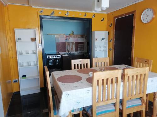 a dining room with a table and chairs and a kitchen at Casa Lo Herrera in Isla de Maipo