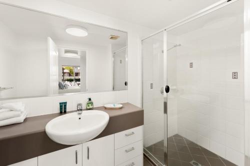 a white bathroom with a sink and a shower at Saltair Retreat in Gold Coast