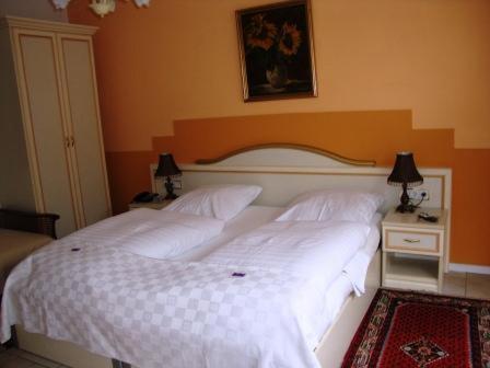 a bedroom with a large white bed with two lamps at Haus Mooren, Hotel Garni in Düsseldorf