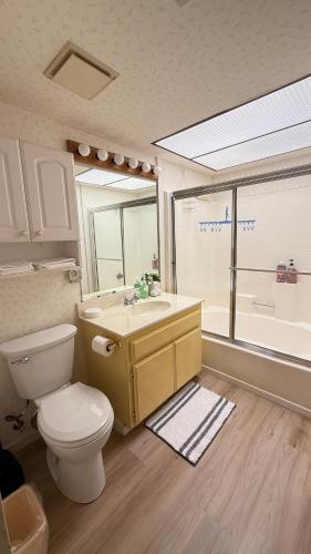 a bathroom with a toilet and a sink and a window at Perfect Coachella Getaway! in Indio