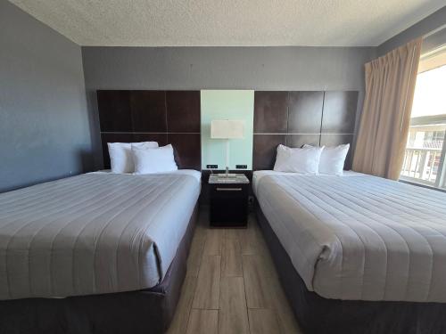 a hotel room with two beds and a window at Beach House Inn in Daytona Beach