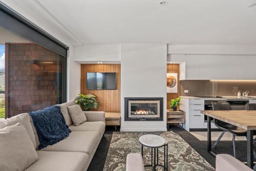 a living room with a couch and a fireplace at Residence du Parc Apartments By Staysouth in Queenstown
