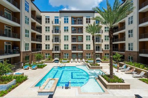 an apartment building with a pool and palm trees at Houston Luxury 1BR-3BD-Pool-Gym in Houston
