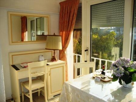 a room with a table and a desk with a window at Haus Mooren, Hotel Garni in Düsseldorf