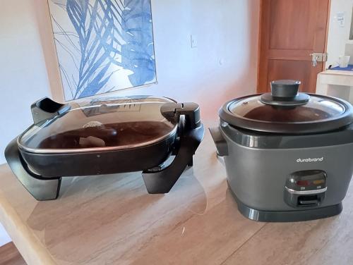 a slow cooker and a pot on a wooden floor at Villa Marina, Nosara in Nosara