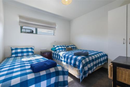 a bedroom with two beds and a window at Virtue Escape - Beachside Bliss at Tokerau Beach in Kaitaia