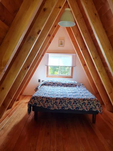 a bedroom with a bed in a attic at Cabaña Alpina Los Treiles in Panguipulli