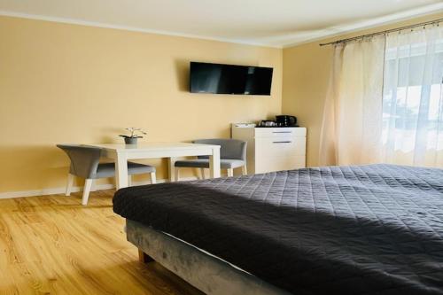 a bedroom with a bed and a desk and a table at Studio in Mi dzywodzie near Baltic Beaches in Międzywodzie