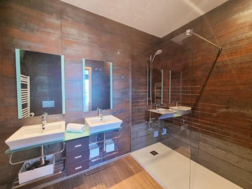 a bathroom with two sinks and two mirrors at Luxury villa with amazing sea view in L'Escala