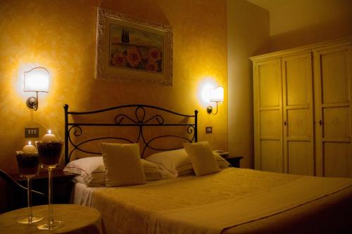 a bedroom with a bed and two lights on the wall at Hotel Ristorante Tre Stelle in Montepulciano