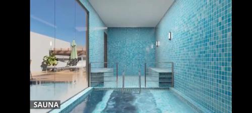 a bathroom with a swimming pool with blue tiles at Dom Del Gaudio AP in Foz do Iguaçu