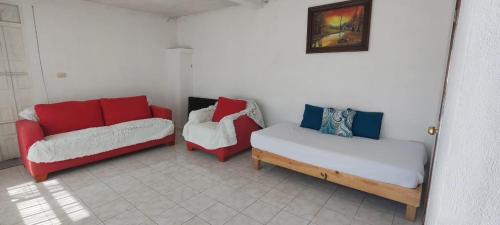 a living room with three beds and a couch at Casa Tlaxcala in Tlaxcala de Xicohténcatl