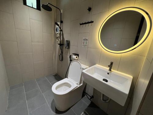 a bathroom with a toilet and a sink and a mirror at 7 minutes driving to TC Beach 123 Guest House in Kuantan