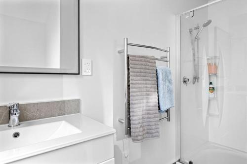 a white bathroom with a sink and a shower at Country Guesthouse Tamahere in Tamahere