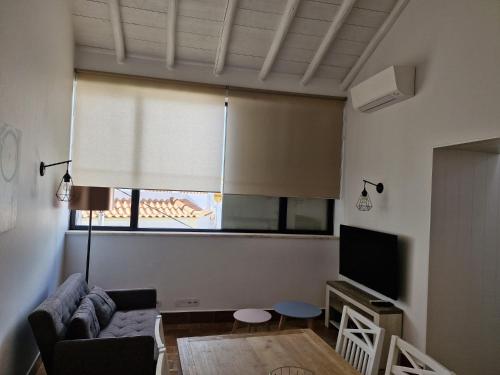 a living room with a couch and a television at River View Ferragudo Terrace Villa in Ferragudo