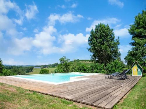 une terrasse en bois à côté d'une piscine avec deux chaises dans l'établissement Charming House in Coubjours with Pool, à Coubjours