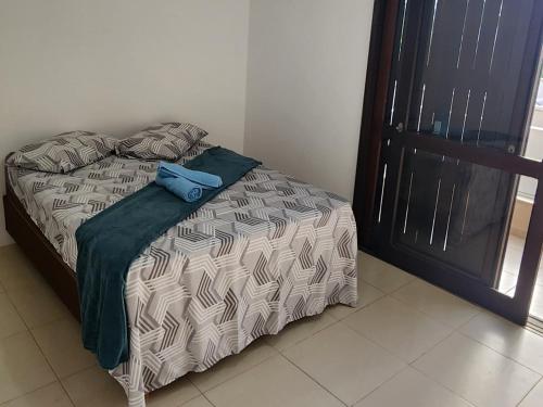 a bed with a blue pillow on top of it at Casa de férias in Arroio do Sal