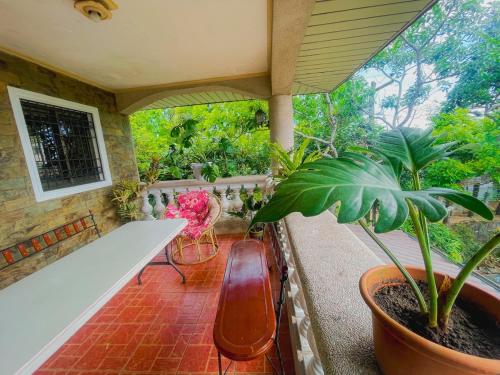 a porch with a white table and plants on it at Spacious room in Tagaytay! Pool, Billiards, Netflx in Tagaytay