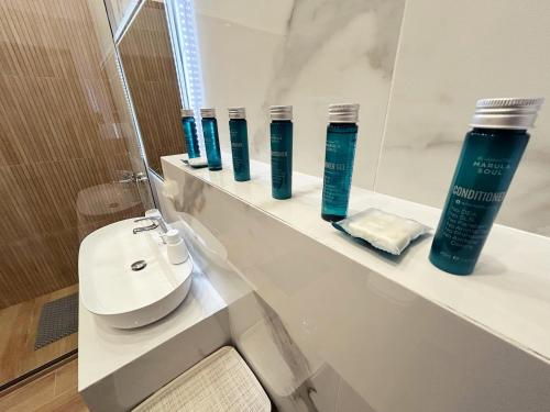 a bathroom with a row of shampoo bottles on a shelf at PEDRO NAVARINO II Laganas in Laganas