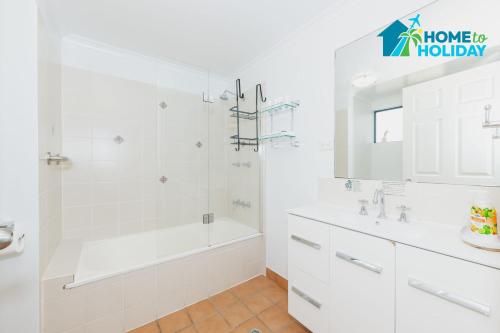 a white bathroom with a tub and a shower at Perfect Position for City and Stadium Access in Townsville