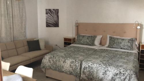 a bedroom with a bed and a couch at 14 Cedar Entire Property in Dangriga