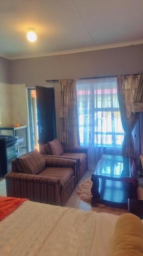 a living room with a couch and a table at Little Haven! in Rustenburg