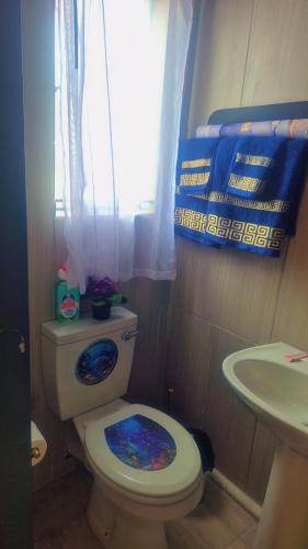 a bathroom with a toilet and a sink and a window at Little Haven! in Rustenburg