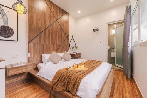 a bedroom with a large bed with a wooden headboard at The Morris Boutique Hotel 2 - O'TEL in Da Lat