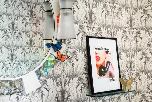 a mirror and a picture on a wall with butterflies at Kimpton Hotel Monaco Washington DC by IHG in Washington