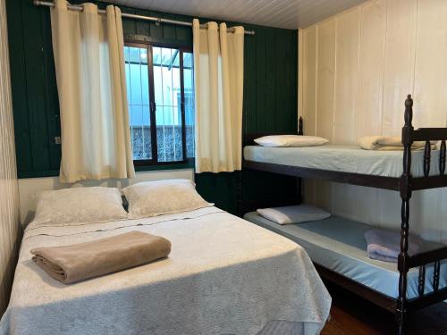 a bedroom with two bunk beds and a window at CASA SUZENA - Penha SC a 300 metros do Beto Carrero e Praias in Penha