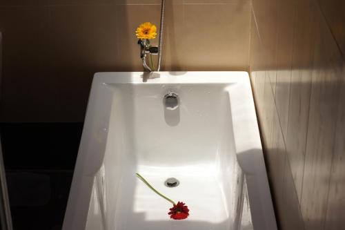 a white sink with a flower on top of it at Gold Sand Beach Bungalow in Phu Quoc