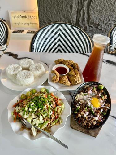 a table with plates of food on a table at Jardin De Ysabelle in Tagpupungan