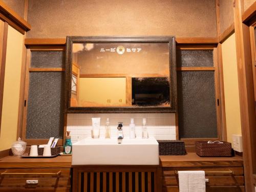 a bathroom with a sink and a mirror at Ryouriryokan Asahikan in Shionoha