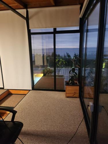 a living room with a large window and a chair at Casa con vista al mar in Quillaipe