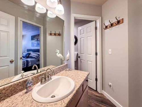 ein Badezimmer mit Waschbecken und Spiegel in der Unterkunft Beautiful Inn Building Updated Condo 211 in Garden City