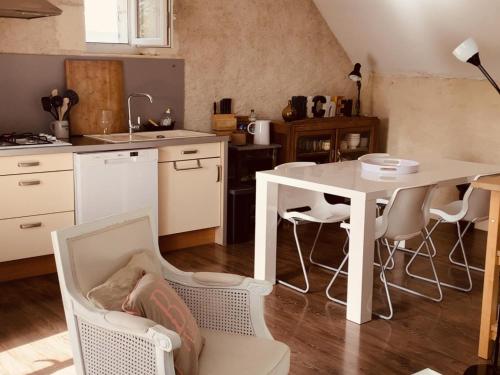 - une cuisine avec une table et un lit bébé dans l'établissement Gîte de charme avec Spa privatif en Touraine - proche châteaux, zoo, et balades pittoresques - FR-1-381-84, à Bridoré