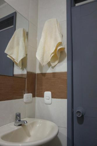 a bathroom with a sink and a mirror with towels at Apartamento Familiar con ubicación estratégica in Ibagué