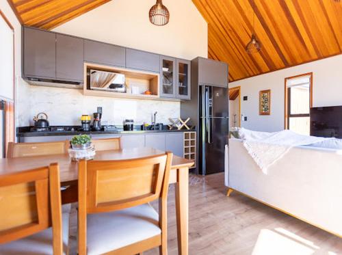a kitchen with a table and a dining room at Cabanas Purunã Ipê-Amarelo in Balsa Nova
