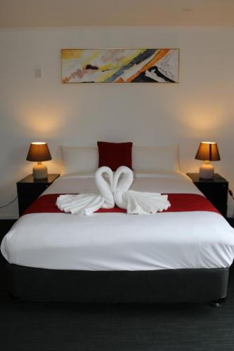 a bedroom with a bed with two towels on it at Nova Motel in Auckland