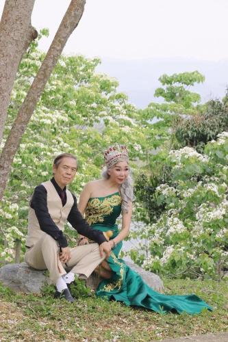 a man and a woman sitting on a rock at Miaoli Sanyi Shantongyazhu Homestay in Sanyi