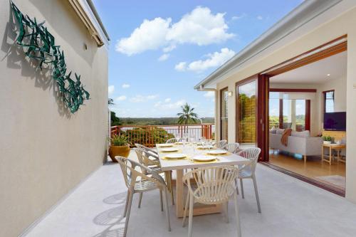 a dining room with a table and chairs on a patio at Penthouse at Colonial in Noosaville