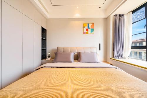 a bedroom with a large bed with a large window at Dreamscape Retreat Three-bedroom suite near Atlantis Hotel Sanya in Sanya