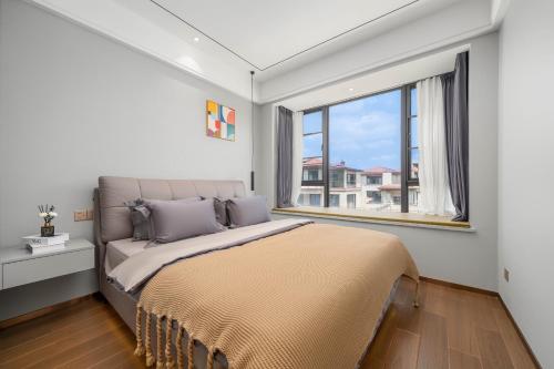 a bedroom with a large bed and a window at Dreamscape Retreat Three-bedroom suite near Atlantis Hotel Sanya in Sanya