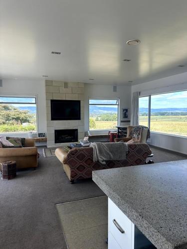 a living room with couches and a flat screen tv at Homewood in Matamata
