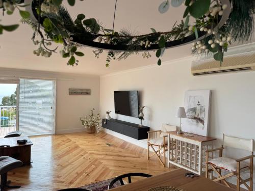 a living room with a table and a tv at Seaside Serenity in Mount Martha